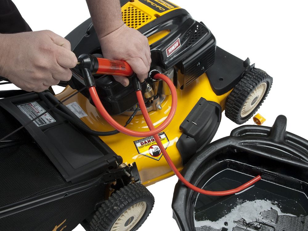 Person using a siphon pump to drain oil from a yellow lawn mower into a black container