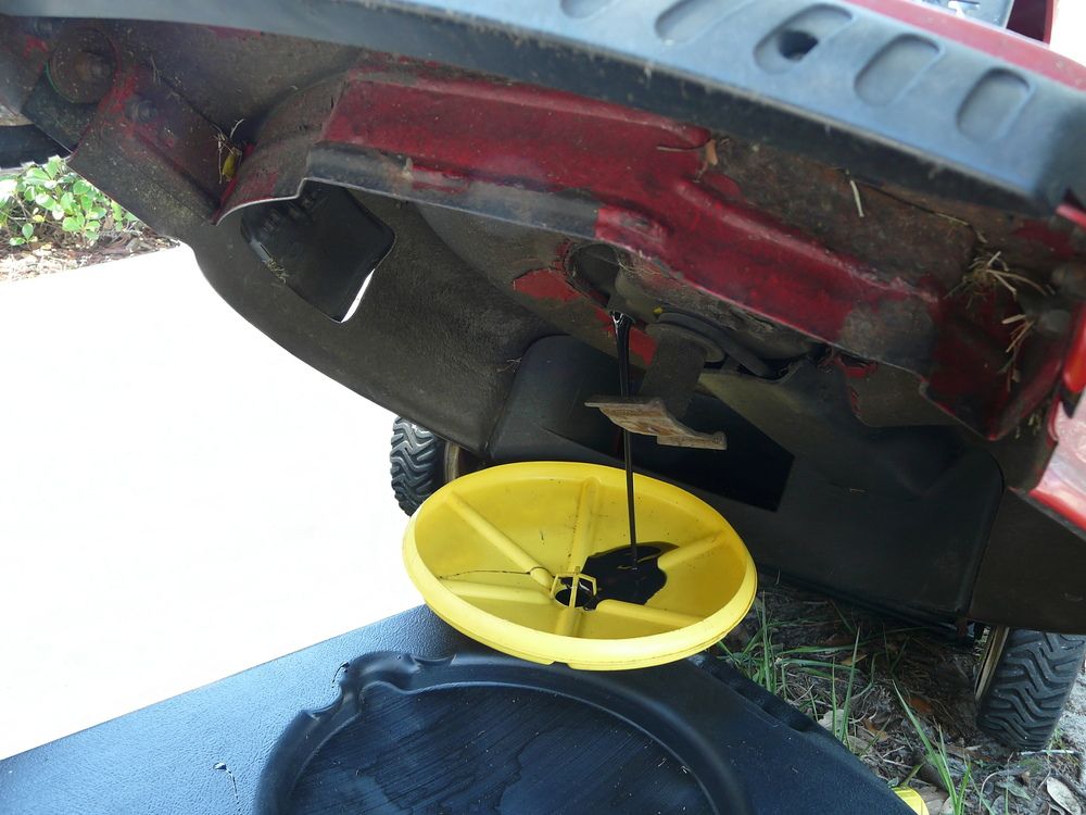 Lawn mower oil being drained by tilt method